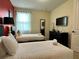 Comfortable bedroom with two twin beds, a dark dresser, and a wall-mounted TV at 7668 Wilmington Loop, Kissimmee, FL 34747