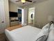 Comfortable bedroom with plush bedding, an adjacent bathroom, and a TV with dresser at 7668 Wilmington Loop, Kissimmee, FL 34747