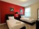 Themed bedroom with twin beds, colorful wall art, and bright natural light at 7668 Wilmington Loop, Kissimmee, FL 34747