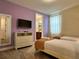 Cozy bedroom with twin beds, TV, dresser, and ensuite bathroom access at 7668 Wilmington Loop, Kissimmee, FL 34747
