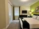 Comfortable bedroom with a queen bed, TV, and green accent wall at 7668 Wilmington Loop, Kissimmee, FL 34747