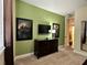 Bright bedroom with decorative art, carpet floors, a dresser, and a wall-mounted TV for entertainment at 7668 Wilmington Loop, Kissimmee, FL 34747