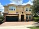 Stunning two-story home featuring a tile roof, brick accents, and manicured landscaping at 7668 Wilmington Loop, Kissimmee, FL 34747
