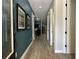 Inviting hallway with wood flooring and decorative wall art leading to other rooms in the house at 7668 Wilmington Loop, Kissimmee, FL 34747