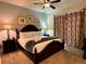 This main bedroom is complete with lamps, a ceiling fan, and framed pictures for a relaxing retreat at 7668 Wilmington Loop, Kissimmee, FL 34747