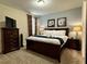 Bedroom with a dark wood bed, dresser, and lamps, creating a relaxing atmosphere at 7668 Wilmington Loop, Kissimmee, FL 34747