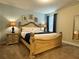 Bedroom featuring a decorative bed frame, window with curtains, and carpet flooring at 7668 Wilmington Loop, Kissimmee, FL 34747