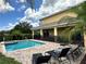 This outdoor oasis features a private pool and spa surrounded by lush landscaping and plenty of lounge chairs at 7668 Wilmington Loop, Kissimmee, FL 34747