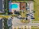 Overhead view of a community pool, playground, parking, and walkways between townhomes at 9819 Red Eagle Dr, Orlando, FL 32825