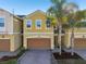 Exterior shot of a yellow stucco house with a brown garage door and landscaped front yard at 9819 Red Eagle Dr, Orlando, FL 32825