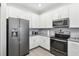 Modern kitchen featuring stainless steel appliances, white cabinets, and gray countertops at 9819 Red Eagle Dr, Orlando, FL 32825