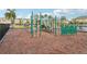 Community playground area featuring play structures, mulch ground covering, and lush landscaping at 9819 Red Eagle Dr, Orlando, FL 32825