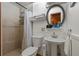 Well-lit bathroom featuring a pedestal sink, tiled shower, and decorative oval mirror at 10301 Us Highway 27 # 114, Clermont, FL 34711