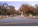 Scenic entrance to Vacation Village Resort with lush greenery, mature trees, and white fencing at 10301 Us Highway 27 # 114, Clermont, FL 34711