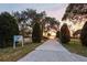 Scenic driveway leading to a lake house, enveloped by lush greenery and a serene sunset backdrop at 10301 Us Highway 27 # 114, Clermont, FL 34711