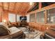 Inviting living room with wood-paneled walls, a fireplace, comfortable leather seating, and natural light at 10301 Us Highway 27 # 114, Clermont, FL 34711