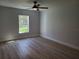 A bright bedroom featuring a ceiling fan, light gray walls, and wood-look floors at 12913 Sw 82Nd Avenue Rd, Ocala, FL 34473