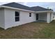 Exterior view of stucco home featuring a dark roof and covered patio at 12913 Sw 82Nd Avenue Rd, Ocala, FL 34473