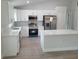 Modern kitchen featuring stainless steel appliances, white cabinetry, and a spacious island with quartz countertop at 12913 Sw 82Nd Avenue Rd, Ocala, FL 34473