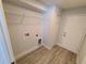 Laundry room with wood-look floors, utility sink hookups, and white walls at 12913 Sw 82Nd Avenue Rd, Ocala, FL 34473