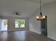 Bright living room with vaulted ceiling, modern light fixture and a large window with view of front yard at 12913 Sw 82Nd Avenue Rd, Ocala, FL 34473