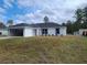 New single-story home featuring a bright white exterior, an open garage, and fresh landscaping at 12929 Sw 82Nd Avenue Rd, Ocala, FL 34473