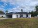 Charming single-story home featuring a modern white exterior, black roof, and well-maintained lawn at 12929 Sw 82Nd Avenue Rd, Ocala, FL 34473