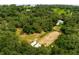 Aerial view of wooded acreage with outbuildings and cleared area at 13045 Mountain Trail, Clermont, FL 34715