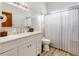 Clean bathroom featuring a white vanity, wood-look floors, and a shower with a striped curtain at 13045 Mountain Trail, Clermont, FL 34715