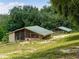 Two rustic chicken coops on a grassy lot, ideal for sustainable living and raising poultry at 13045 Mountain Trail, Clermont, FL 34715