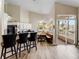 Well-lit kitchen leading to a screened lanai, featuring an island with bar seating and a dining area at 13045 Mountain Trail, Clermont, FL 34715