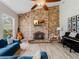 Inviting living room with a brick fireplace, wood-look tile flooring, and cozy seating at 13045 Mountain Trail, Clermont, FL 34715