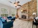 Cozy living room featuring a brick fireplace, wood-look tile flooring, and an abundance of natural light at 13045 Mountain Trail, Clermont, FL 34715