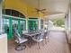 Covered porch with outdoor seating, offering views of the yard at 13045 Mountain Trail, Clermont, FL 34715