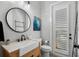 Chic powder room with a wood vanity, round mirror, shiplap accent wall, and stylish black fixtures and accessories at 1324 Utah Blvd, Orlando, FL 32803