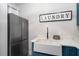 Functional laundry room showcasing a stainless steel refrigerator, farmhouse sink, blue cabinets, and decorative patterned floor at 1324 Utah Blvd, Orlando, FL 32803