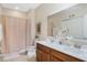 Well-lit bathroom with double vanity and a shower featuring a neutral shower curtain at 1411 Pacific Rd, Poinciana, FL 34759