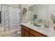 Bright bathroom with double sinks and a marble-look shower curtain, plus vanity storage at 1411 Pacific Rd, Poinciana, FL 34759