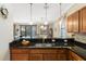 Kitchen view featuring dark granite countertops and an open view to the dining and living areas at 1411 Pacific Rd, Poinciana, FL 34759