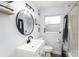 Modern bathroom features a sleek vanity, round mirror, and updated shower with black accents at 1412 Lakecrest Dr, Apopka, FL 32703