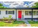 Close up of the front door, shutters, and house number of a charming single story home on a sunny day at 1412 Lakecrest Dr, Apopka, FL 32703