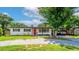 Lovely single story home featuring a bright red front door, dark shutters, and driveway with an attached carport at 1412 Lakecrest Dr, Apopka, FL 32703