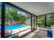 A bright sunroom overlooks the sparkling outdoor pool, perfect for leisure and relaxation at 1412 Lakecrest Dr, Apopka, FL 32703