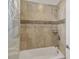 Bathtub and shower combo featuring stone-look tile surround at 14504 Sunbridge Cir, Winter Garden, FL 34787