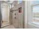 Walk-in shower featuring grey tile and a glass door at 14504 Sunbridge Cir, Winter Garden, FL 34787