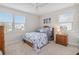 Bright bedroom with a bed dressed in blue-patterned bedding, windows, and a ceiling fan at 14504 Sunbridge Cir, Winter Garden, FL 34787