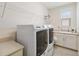 Laundry room with modern washer and dryer and storage space at 14504 Sunbridge Cir, Winter Garden, FL 34787