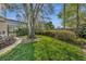 Lush green backyard with mature landscaping, a screened-in pool, and a covered patio area at 1554 Eagle Nest Cir, Winter Springs, FL 32708