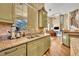 Well-lit kitchen with stainless steel sink, breakfast bar, and views into the living room at 1554 Eagle Nest Cir, Winter Springs, FL 32708