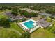 Aerial view of the community pool, tennis courts, and clubhouse amidst lush greenery at 1554 Eagle Nest Cir, Winter Springs, FL 32708